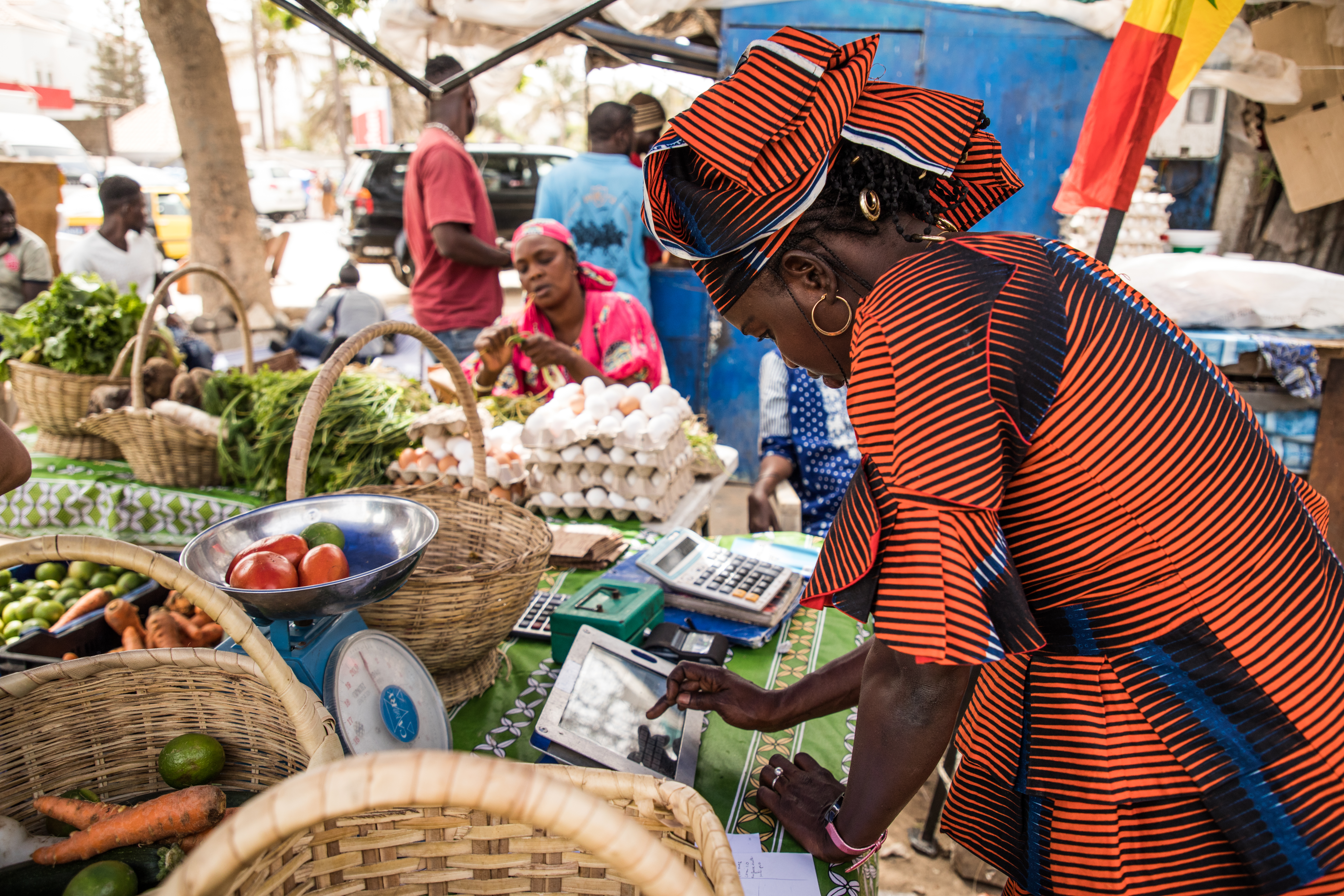  Dakar, Senegal.  Binta is filling the vegetables she sells on her Weebi tablet. The application has helped her manage her stock and sales. Photo: Vincent Tremeau / World Bank
