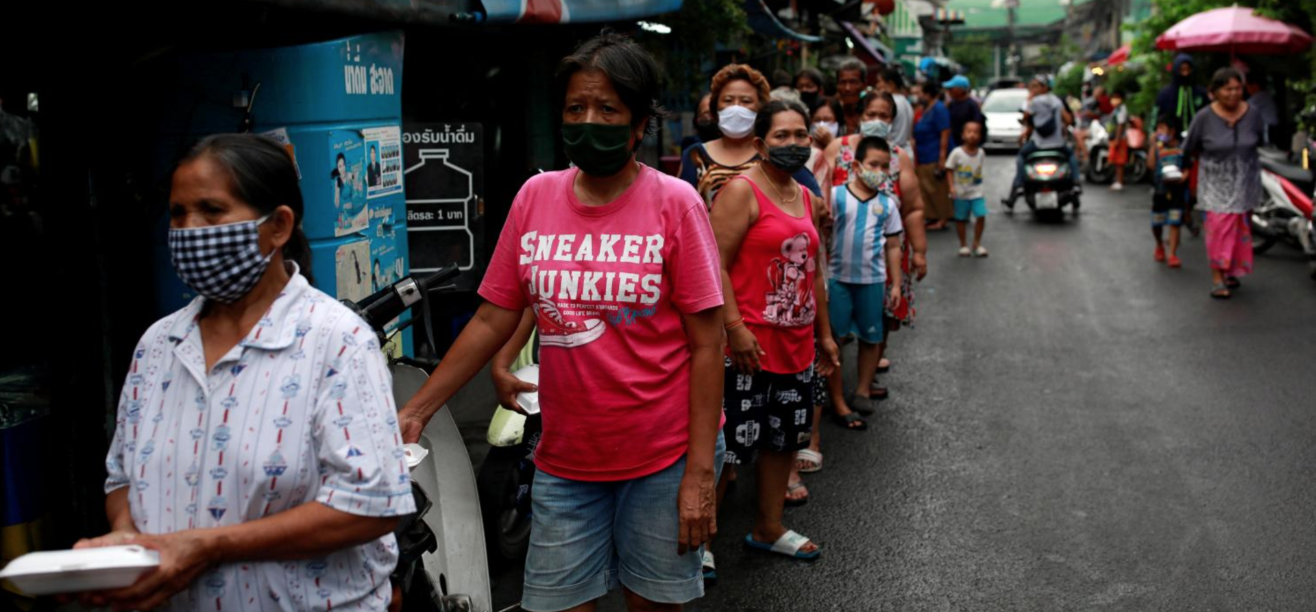 People line up for free food in a slum area following the coronavirus outbreak. Photo: Reuters